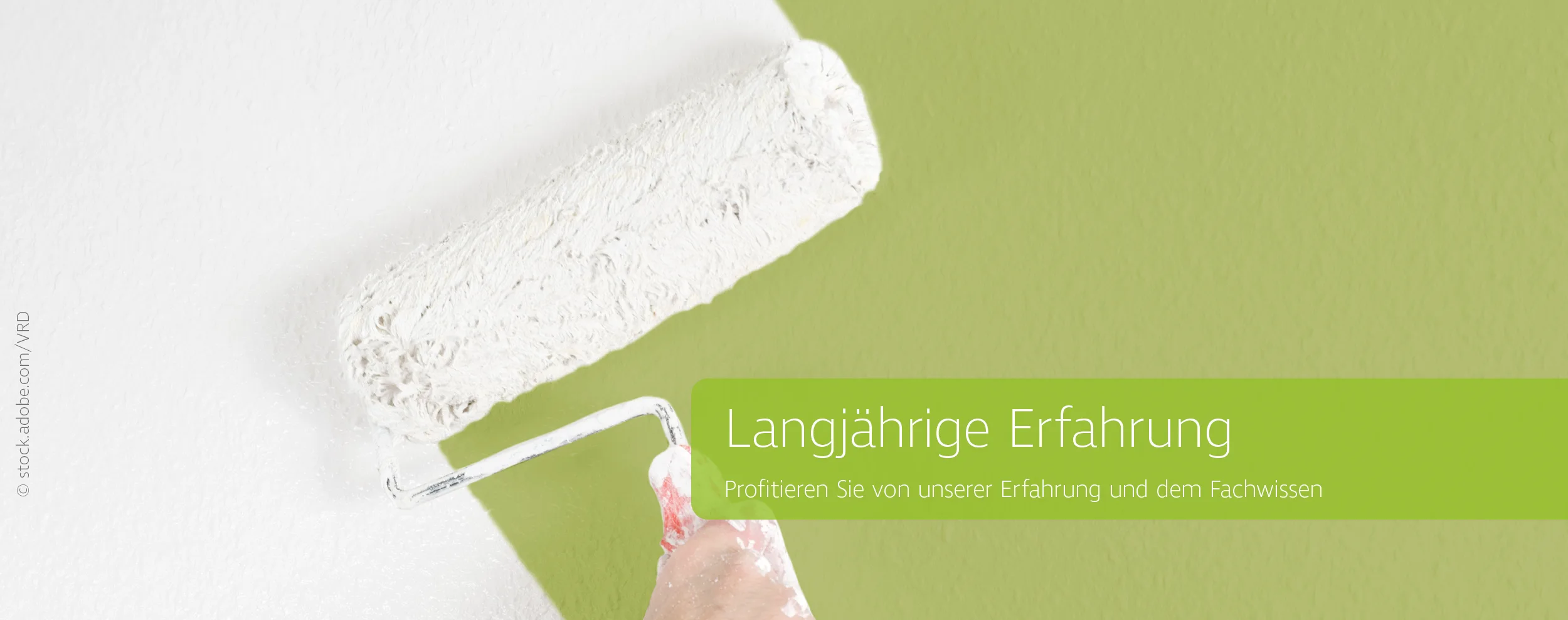 Pinsel malt weiss über grüne Wand